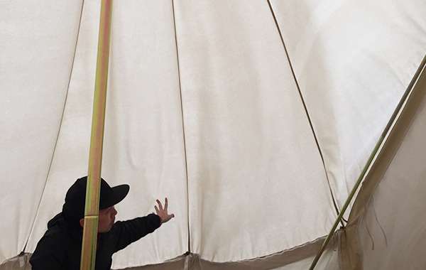 イノウエさんがテントの壁を押さえています